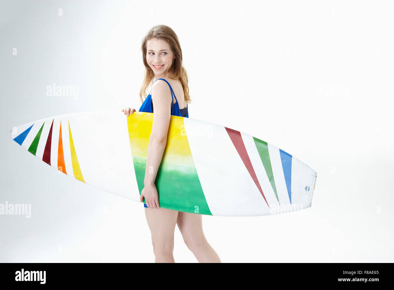 Lady turning her head with holding a surfing board Stock Photo