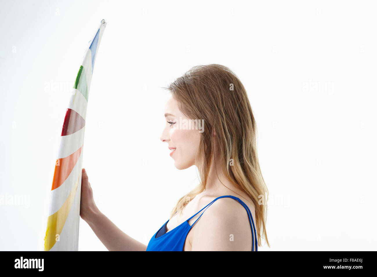 Lady facing a surfing board from the side Stock Photo