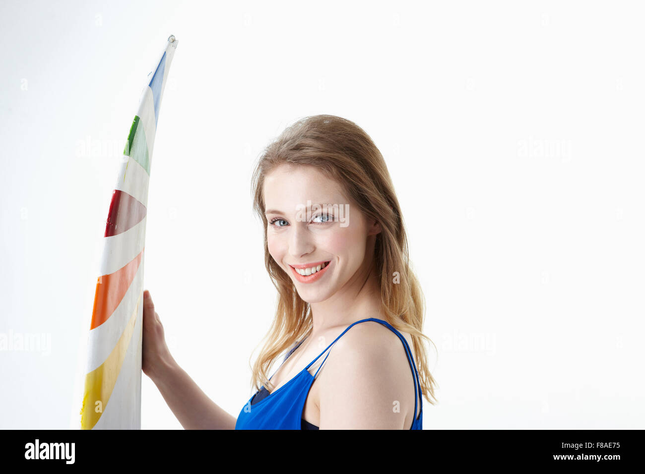 Smiling lady with putting one hand on a surfing board in front of her Stock Photo