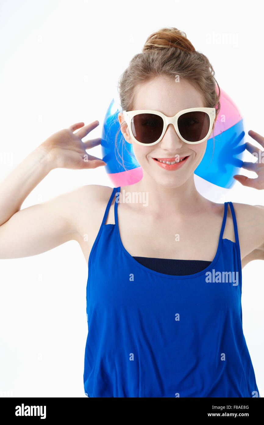 Woman holding a beach ball at the back side of her head Stock Photo