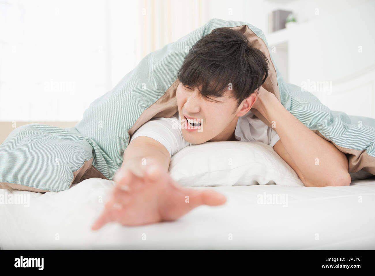 Stressed man lying on his face side and stretching his hand out Stock Photo