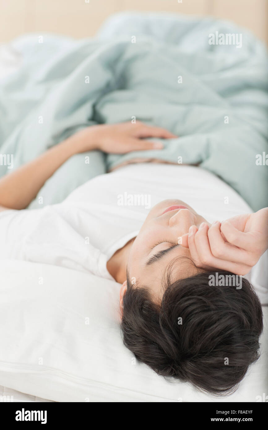 Tired man lying in bed Stock Photo