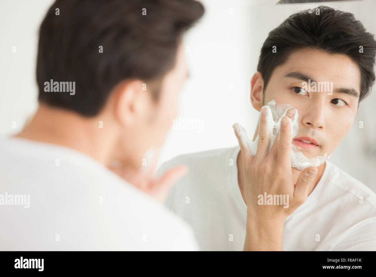 Man applying shaving cream on his face Stock Photo