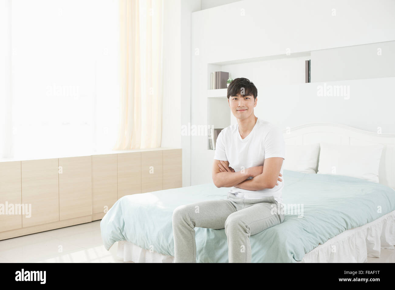 Man sitting on the edge of the bed Stock Photo