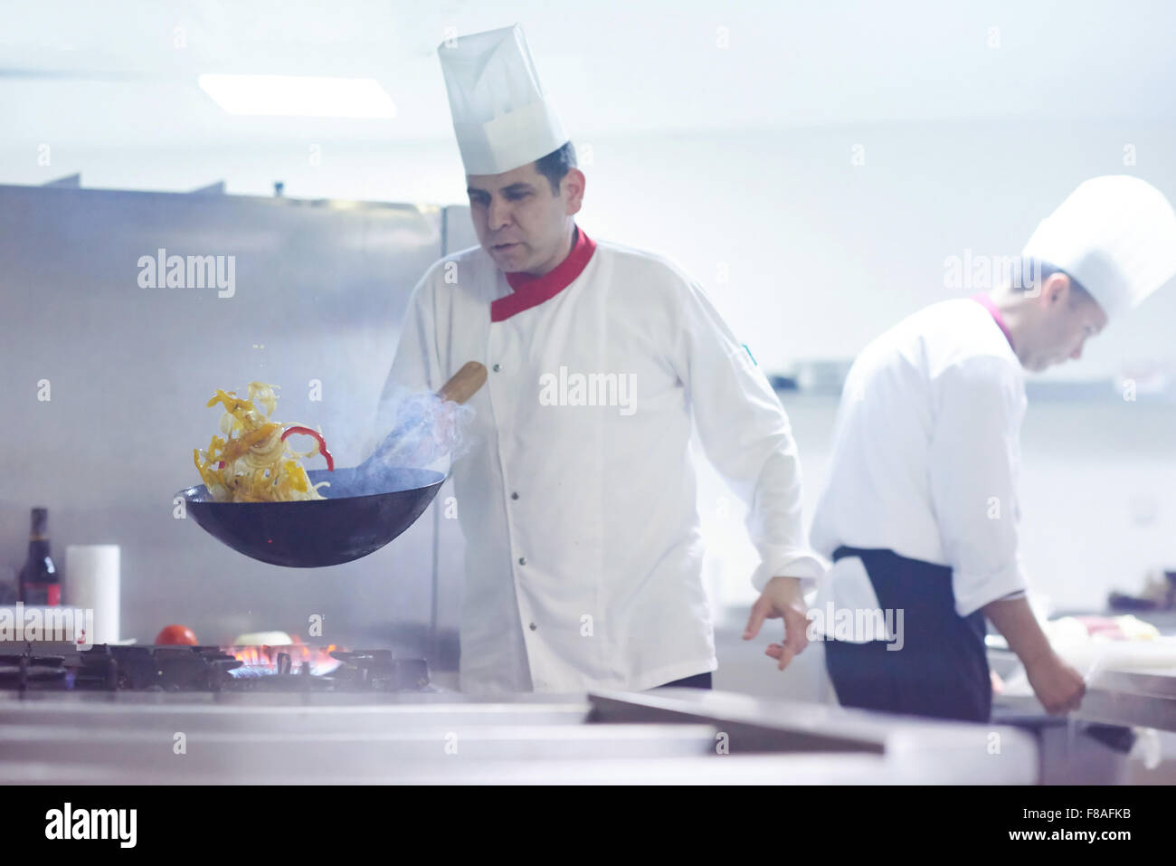 chef in hotel kitchen prepare vegetable food with fire Stock Photo - Alamy