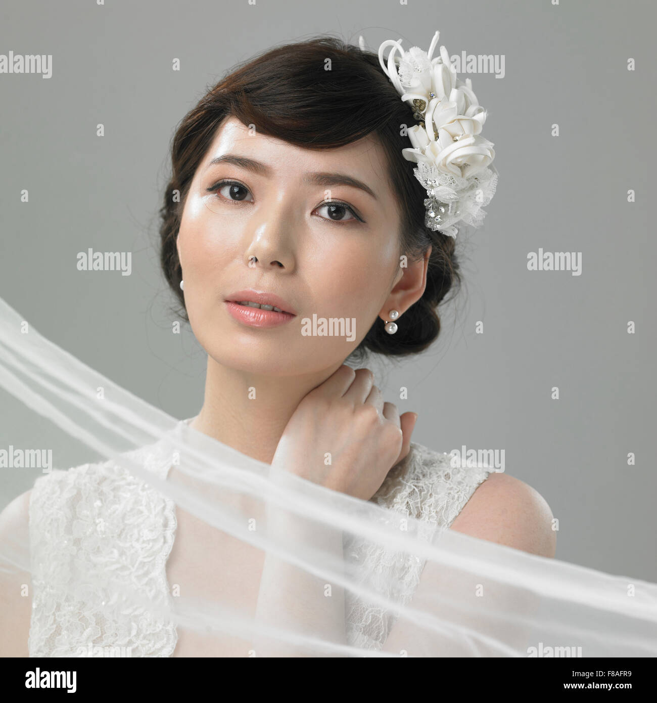 Woman in wedding dress placing her hand on her neck Stock Photo