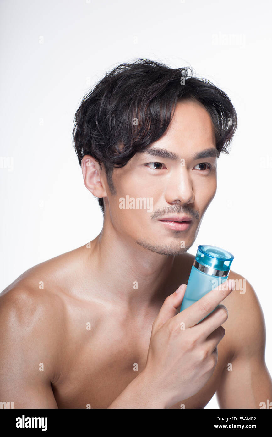 Portrait of young Asian man holding a cosmetic Stock Photo