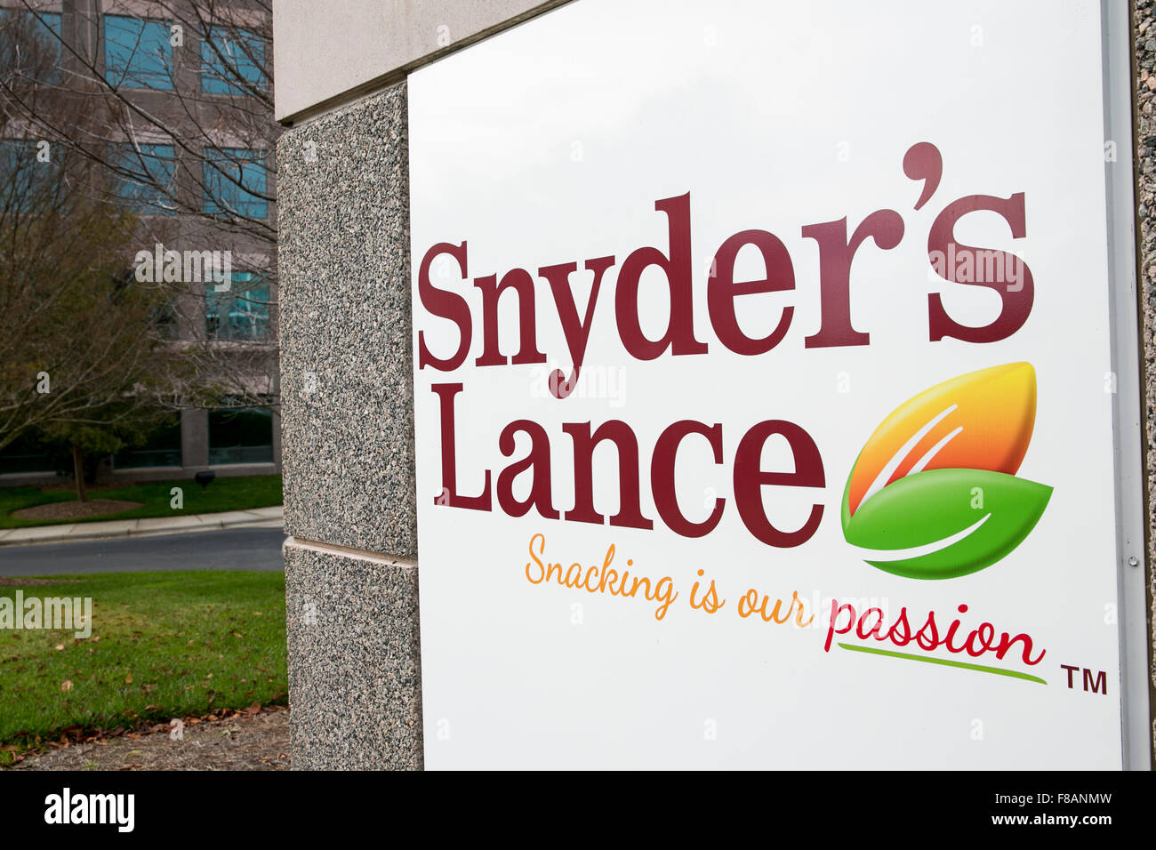 A logo sign outside the headquarters of Snyder's-Lance, Inc., in Charlotte, North Carolina on November 28, 2015. Stock Photo