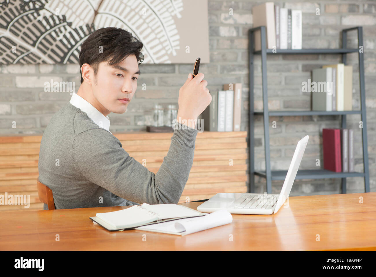 Portrait of young businessman holding a pen at cafe Stock Photo - Alamy