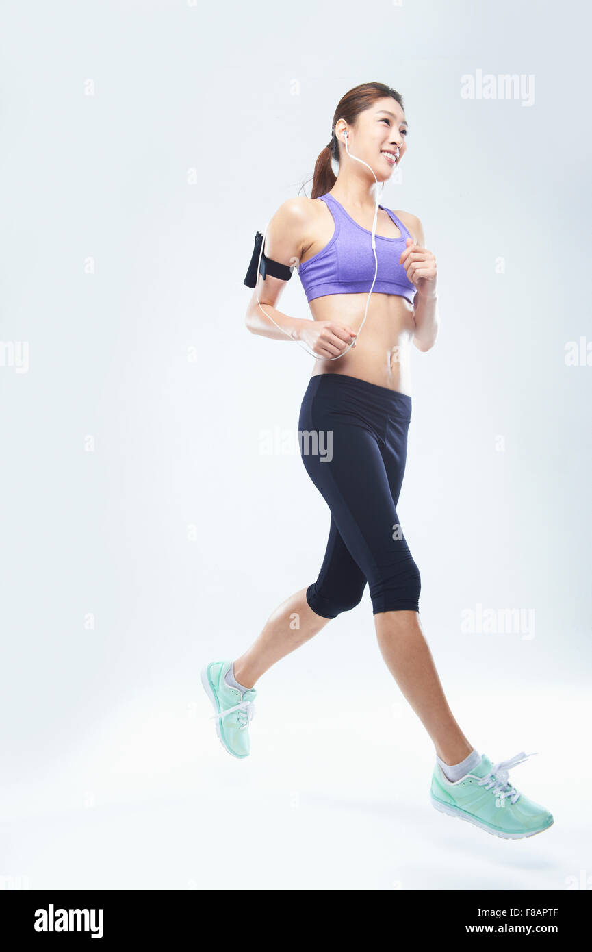 Side view of smiling woman running looking up Stock Photo