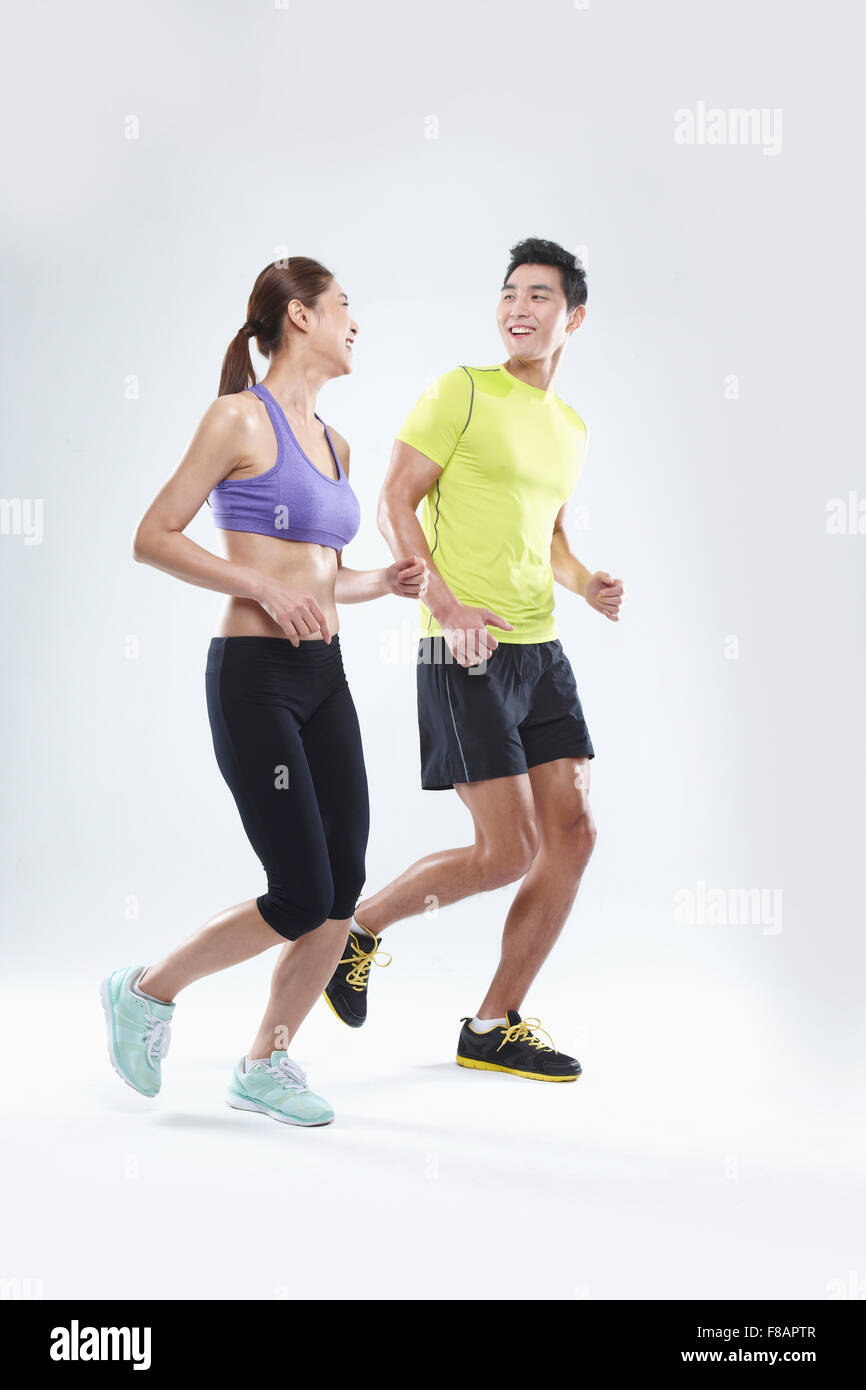 Smiling couple running together face to face Stock Photo