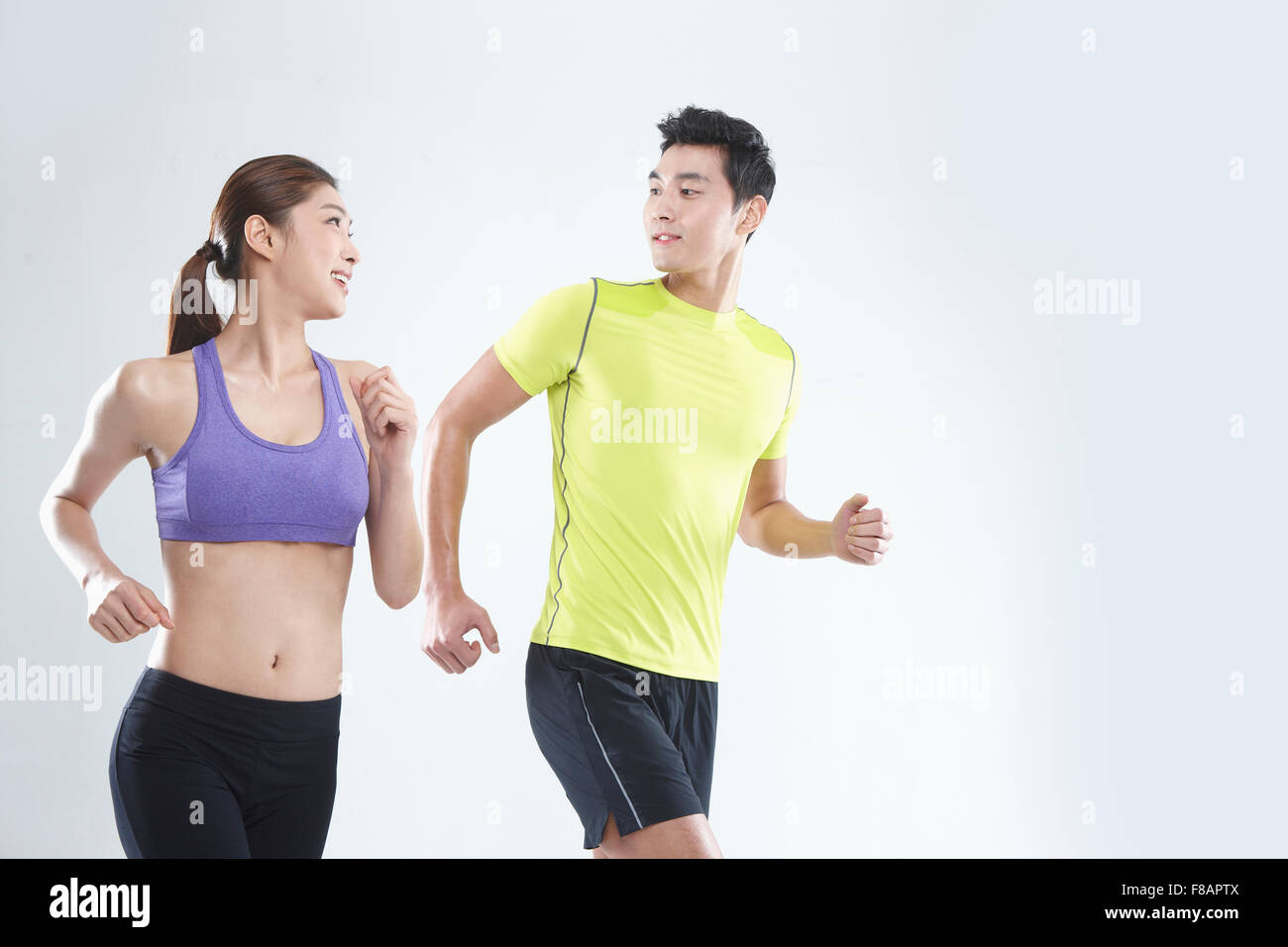 Smiling couple running together face to face Stock Photo