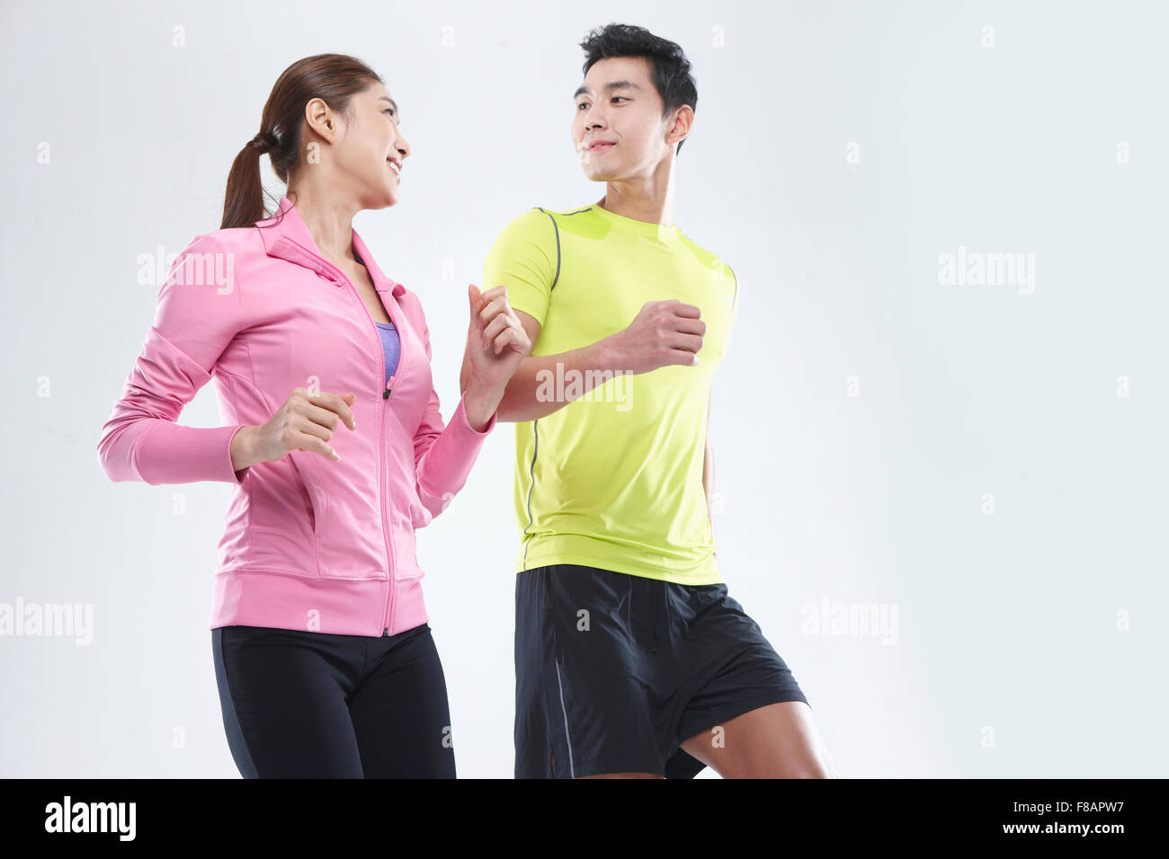 Smiling couple jogging face to face Stock Photo