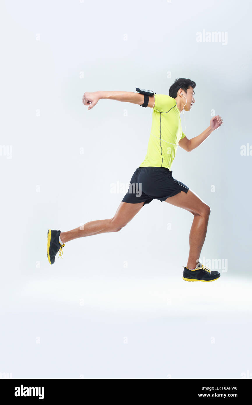 Dynamic side view of man running listening to music Stock Photo