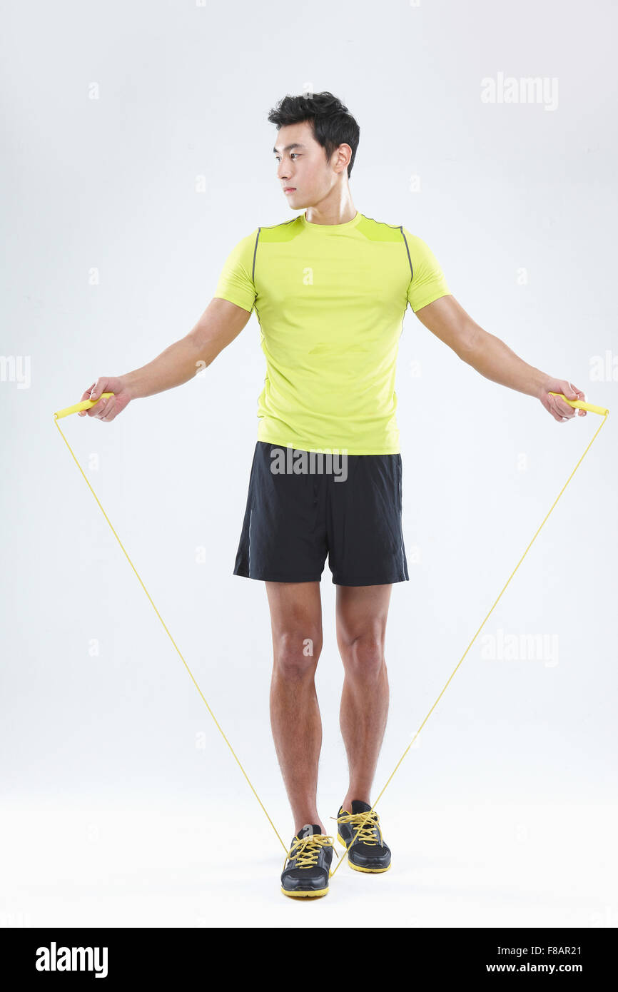 Confident man stepping on a jump rope looking down Stock Photo