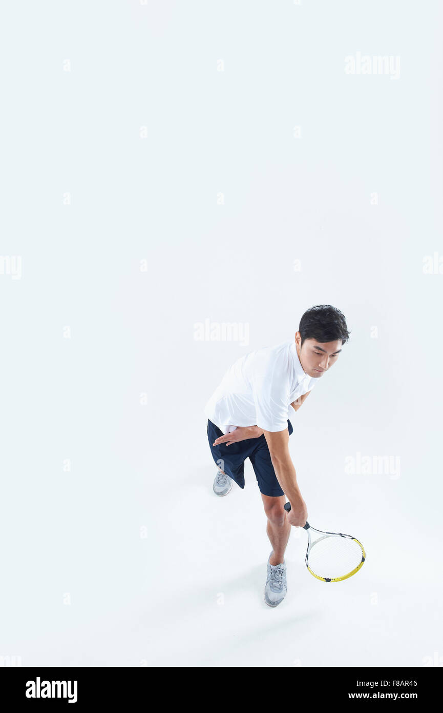 Man swinging a tennis racket looking down Stock Photo