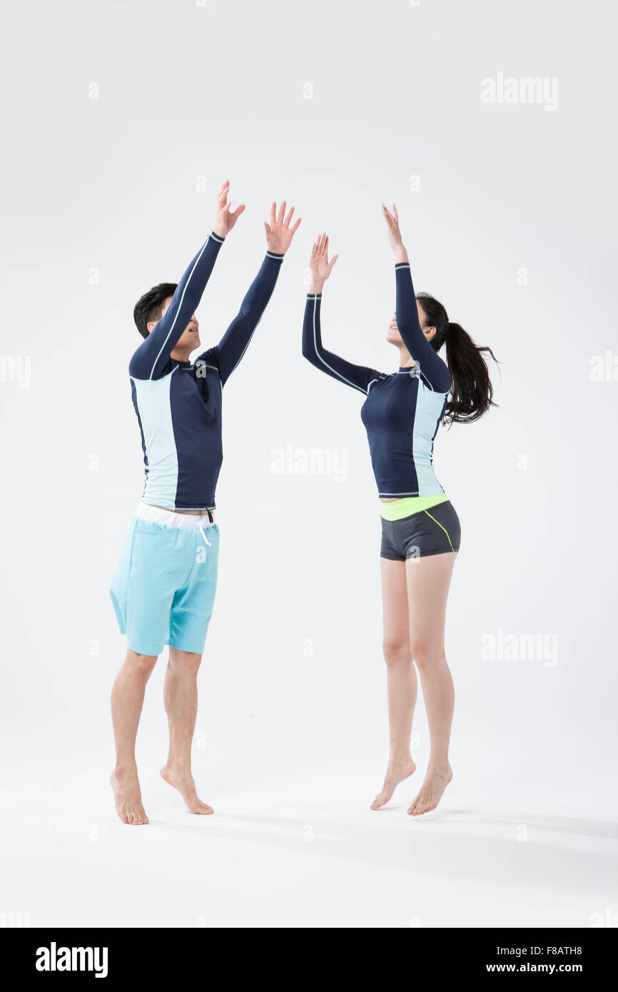 Couple jumping and reaching for the air looking up Stock Photo