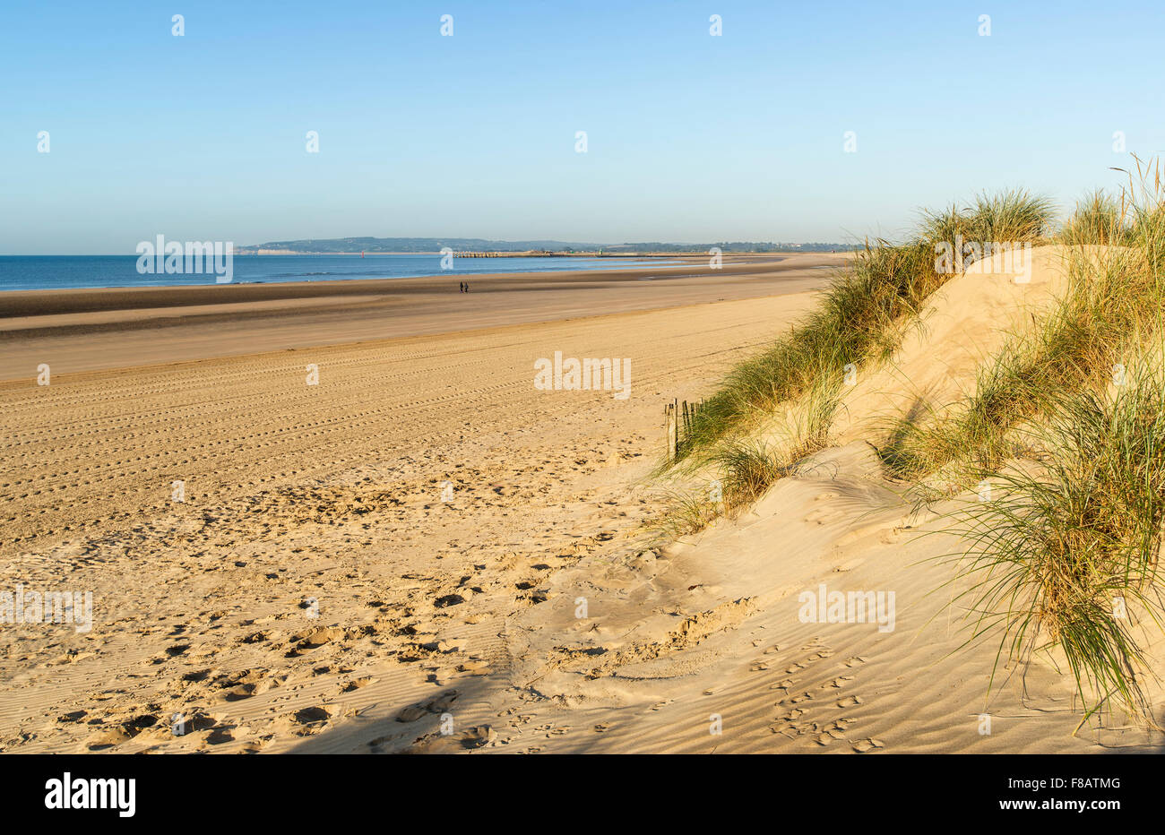 Stunning sunrise over sand dunes system on yellow sand golden beach Stock Photo