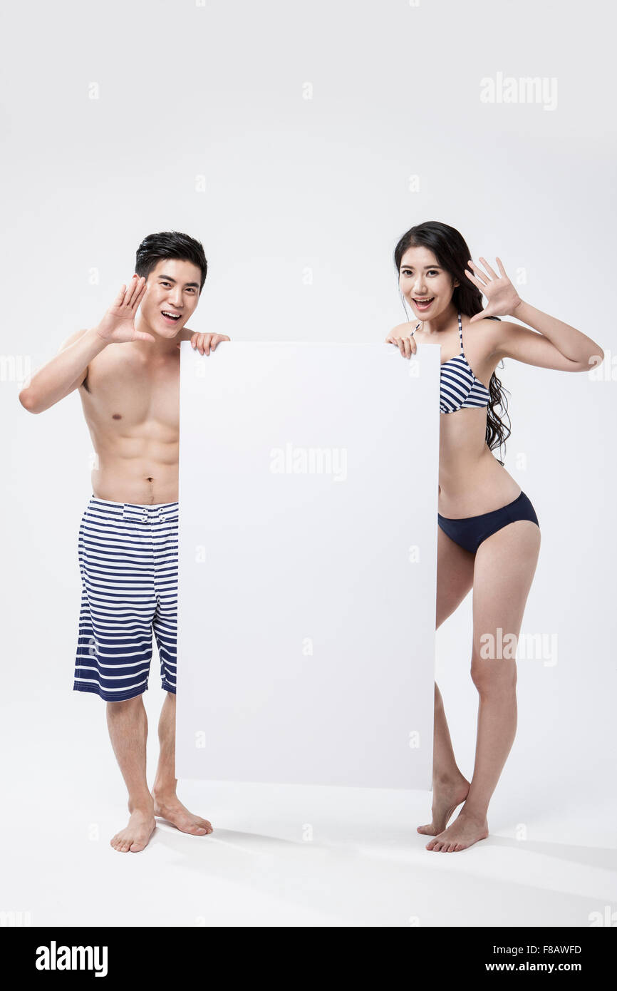 Couple in swimsuits standing with a big paper Stock Photo