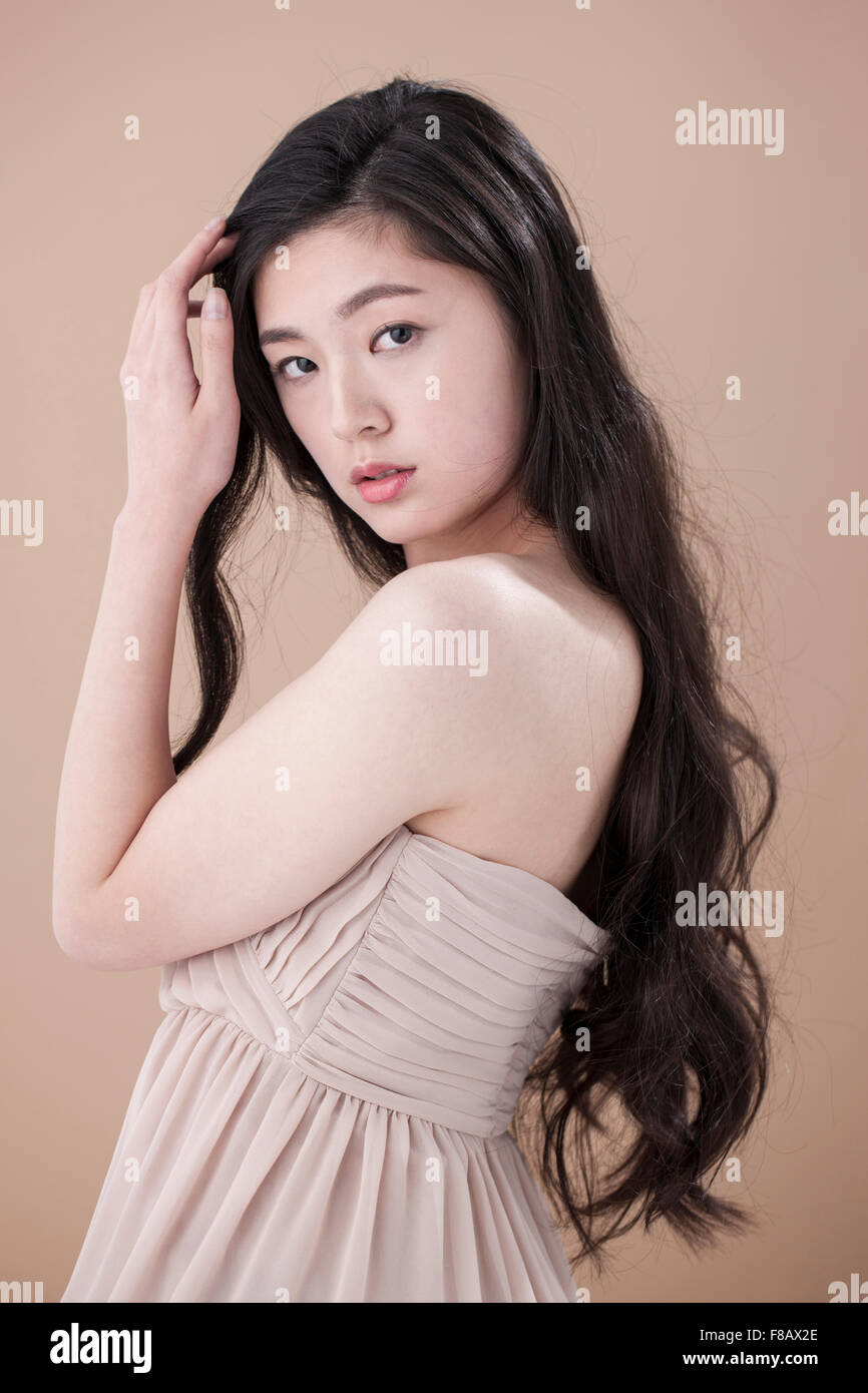 Side View Of Portrait Of Young Woman With Long Wavy Hair Staring
