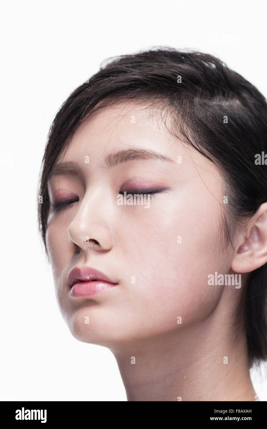 Young woman's face closing eyes, close up Stock Photo