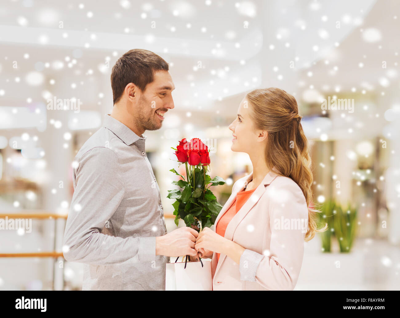 happy young couple with flowers in mall Stock Photo - Alamy