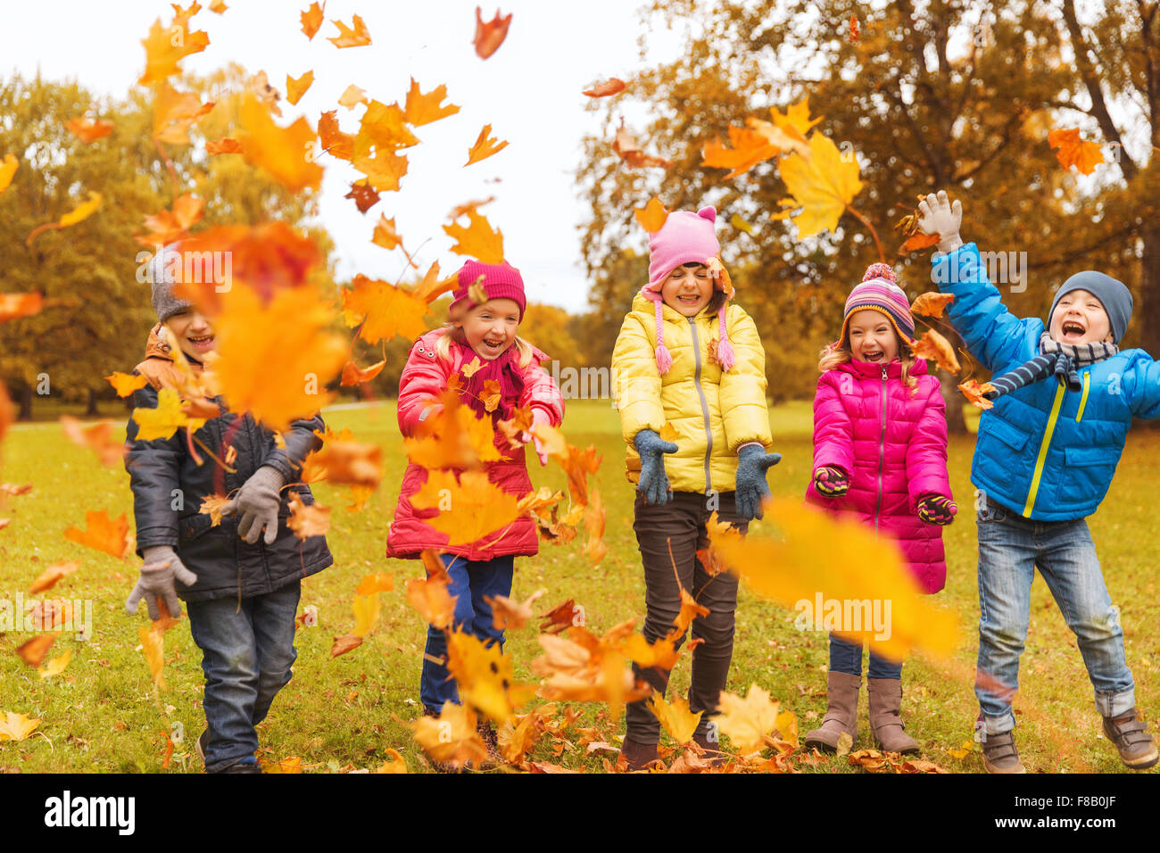 happy children playing with autumn leaves in park Stock Photo - Alamy