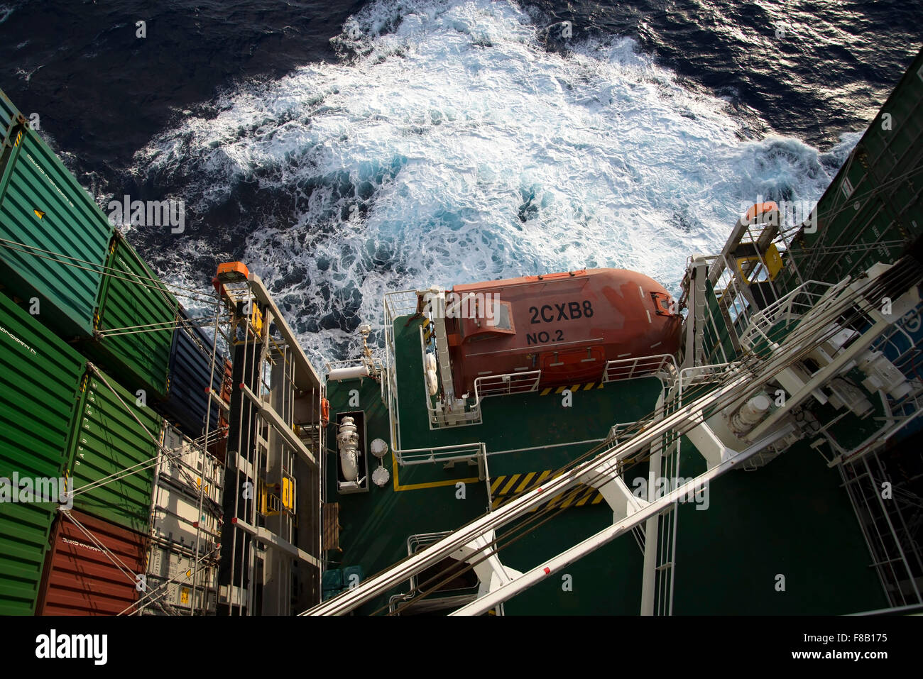 stacked containers in the stern of Corte Real ship in rough sea viewed from high up on the Bridge. Stock Photo