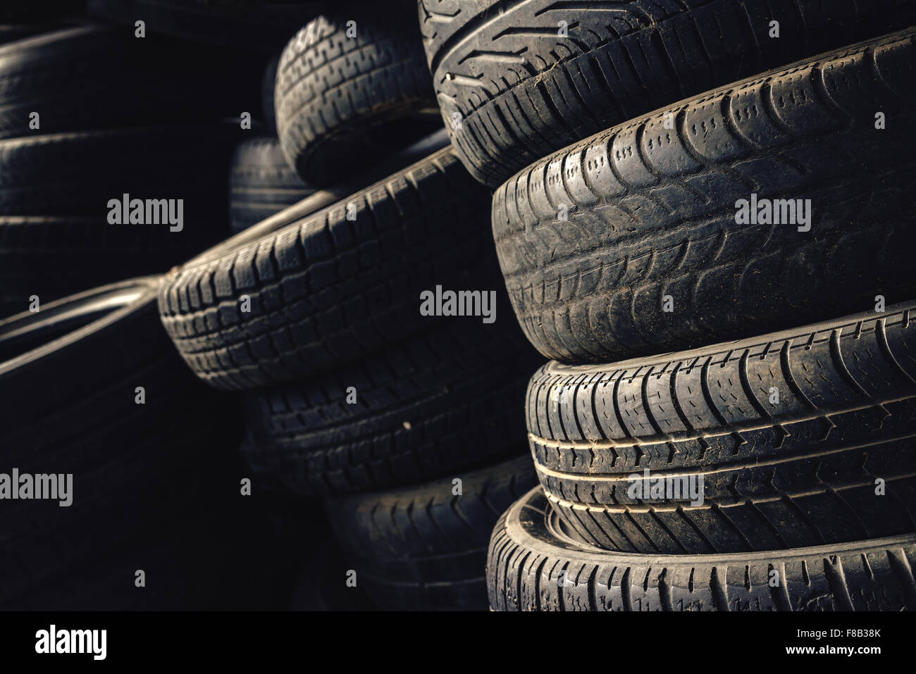 Column stack of old used car tires in secondary car parts shop garage. Stock Photo