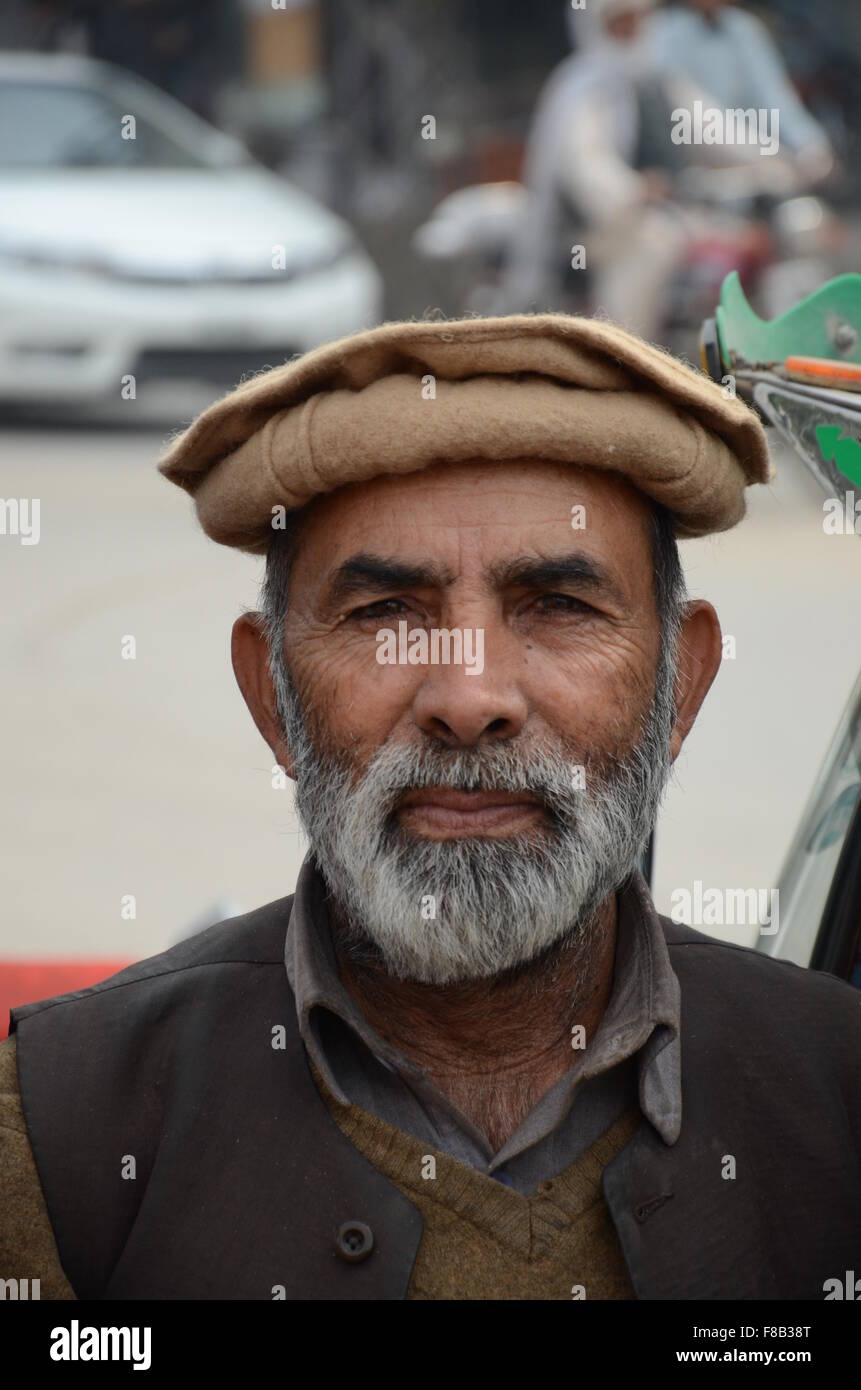 Portrait of Pathan tuk tuk rickshaw driver with Chitrali topi hat Peshawar Pakistan Stock Photo