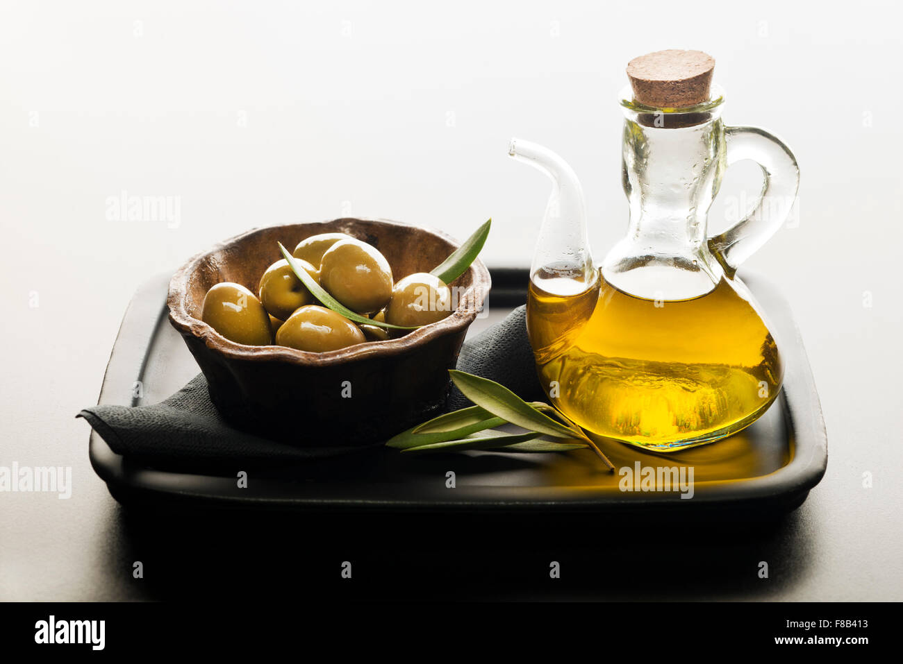 Bottle of premium virgin olive oil and some olives with leaves Stock ...