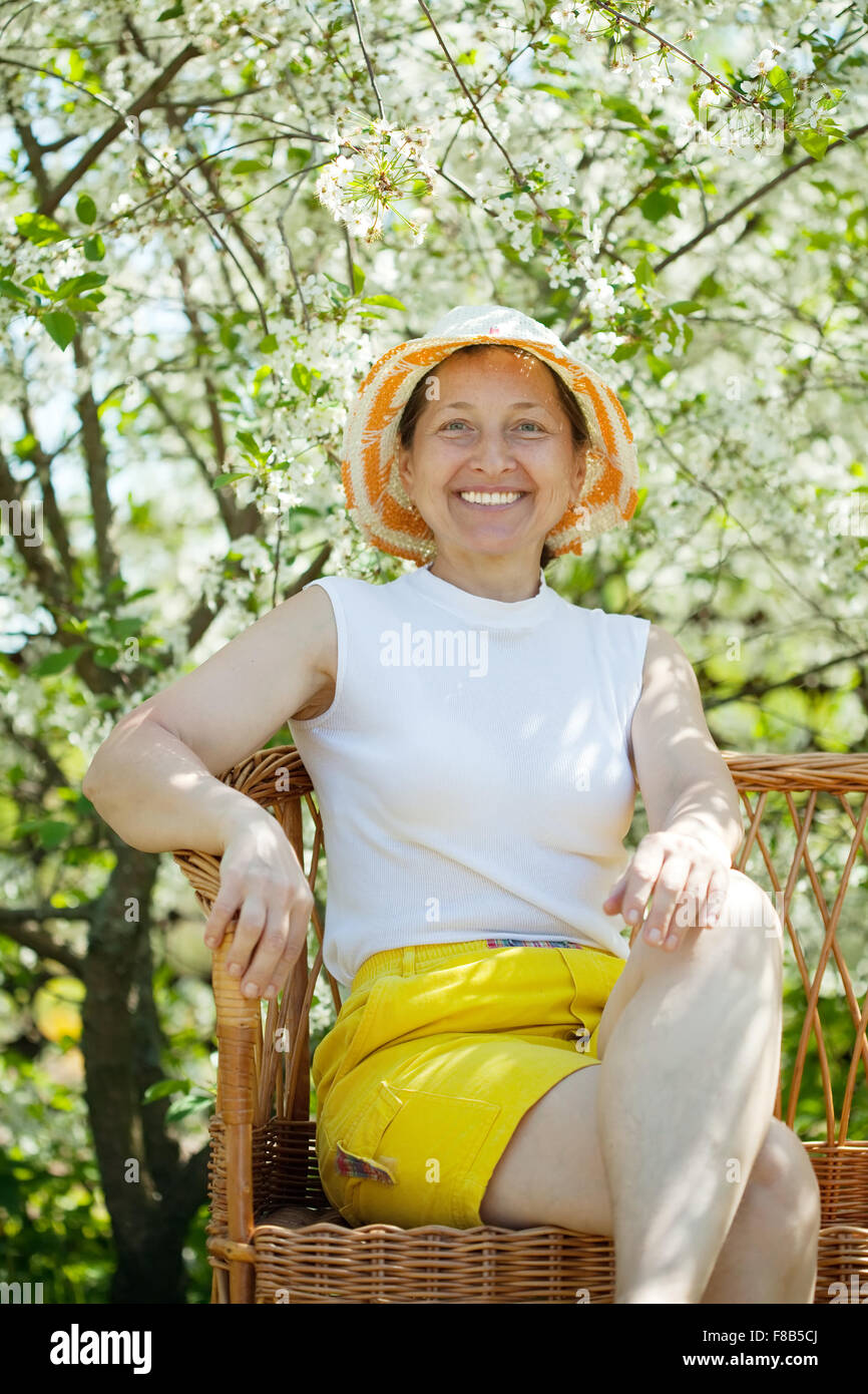 resting mature woman in flowering garden Stock Photo - Alamy