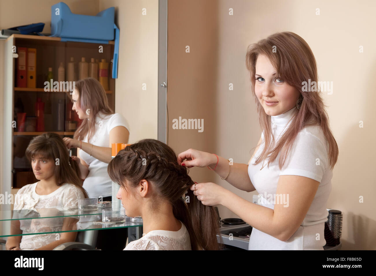 Female hair stylist working with long-haired girl Stock Photo - Alamy