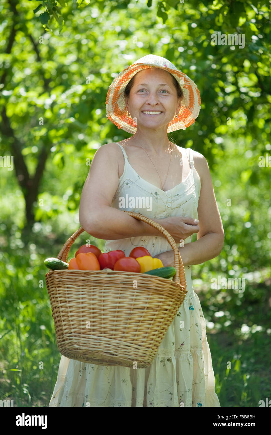 Happy mature woman with basket of harvested vegetables Stock Photo - Alamy