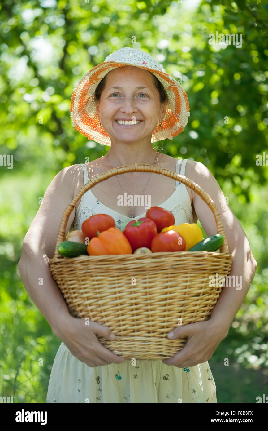 Happy mature woman with basket of harvested vegetables Stock Photo - Alamy