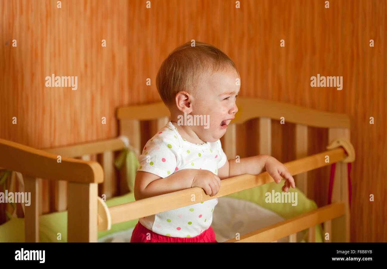 Crying baby of one year old in crib Stock Photo Alamy