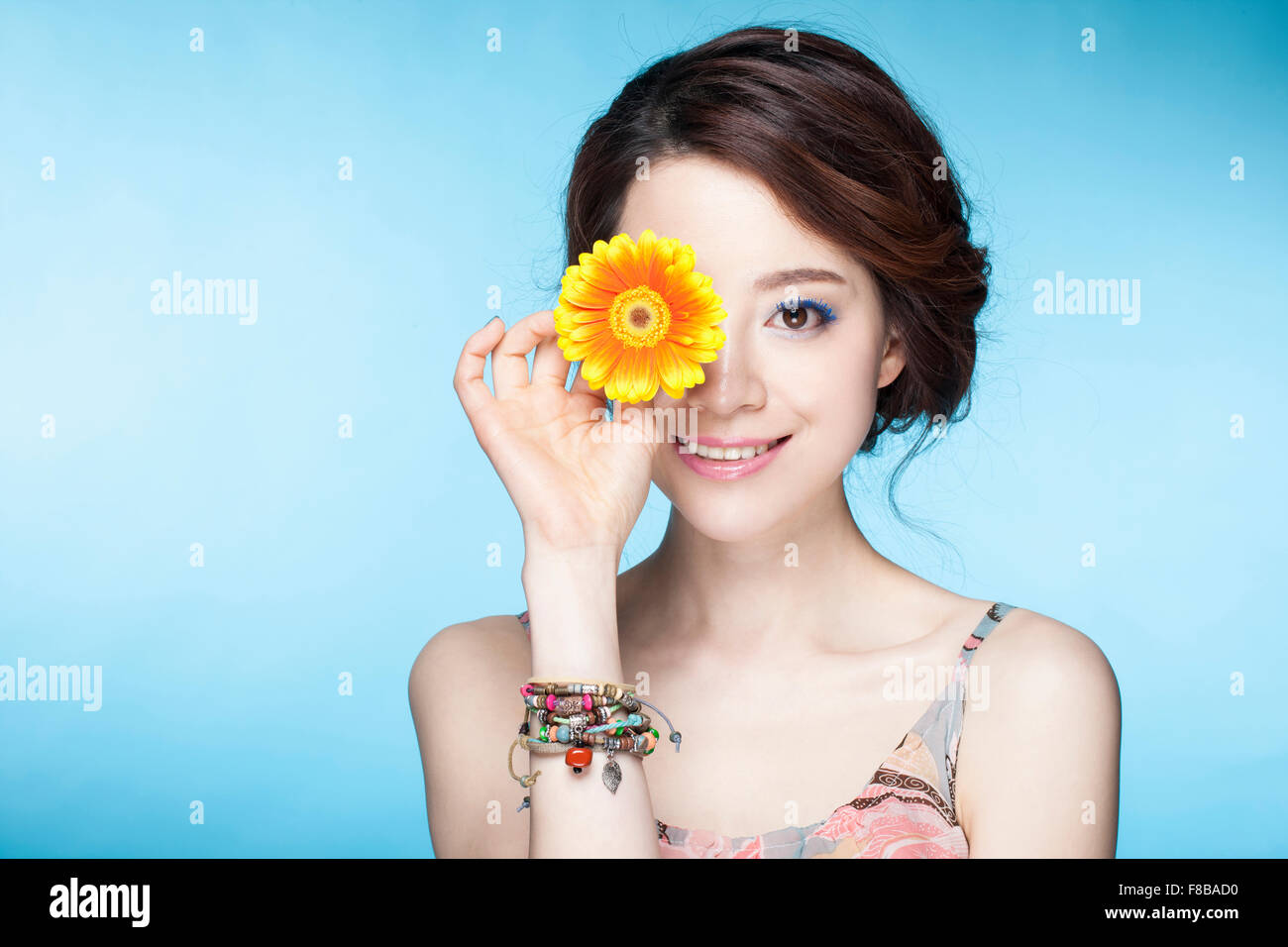 Woman covering an eye with flower hires stock photography and images
