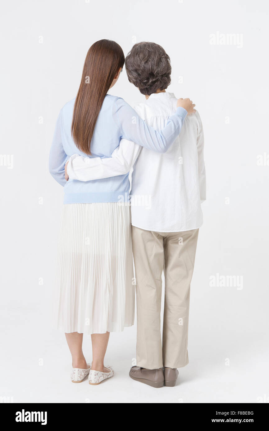 Back Appearance Of Mother And Daughter Putting Their Arm Around Each