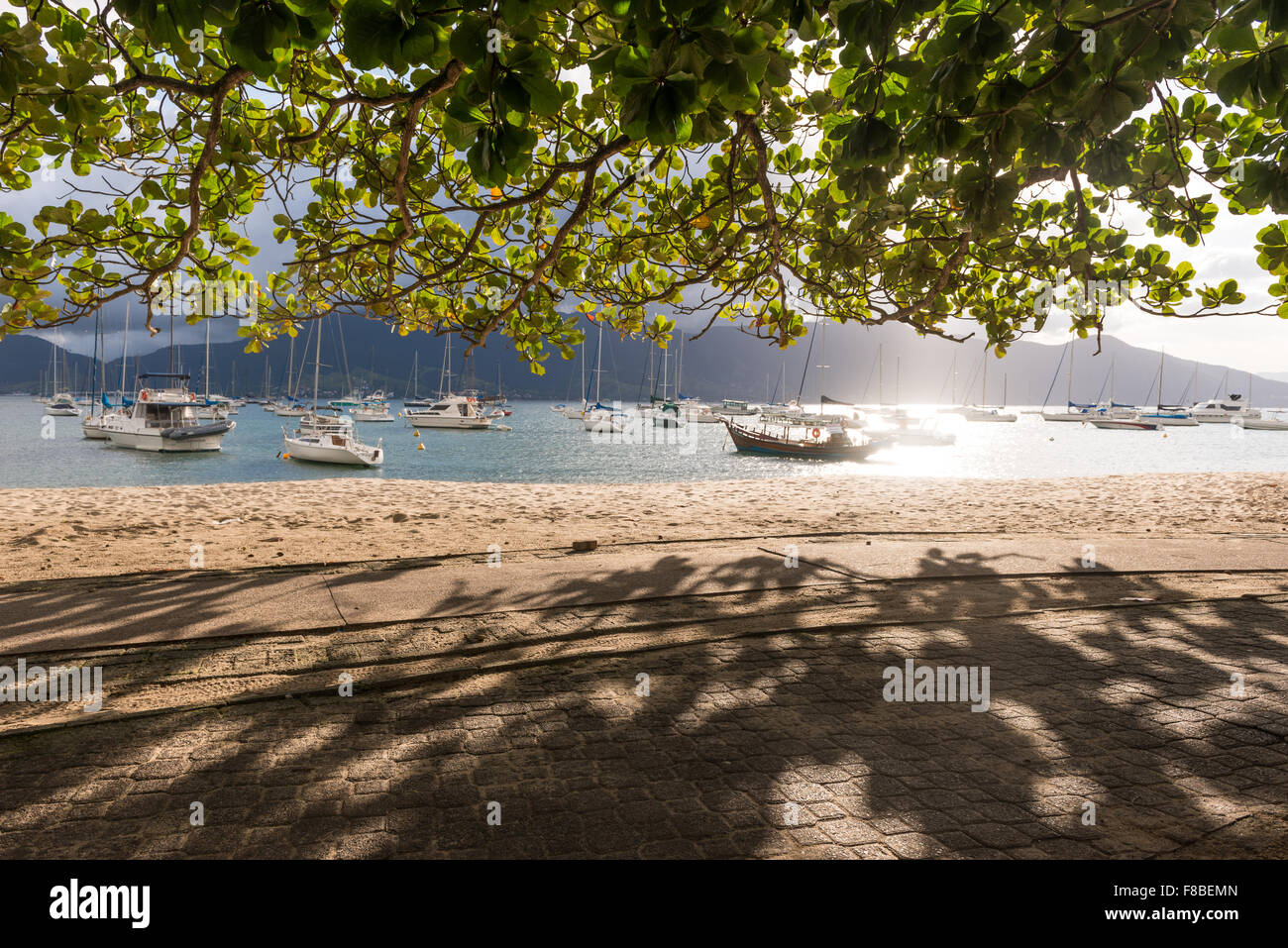 Sidewalk view from boats moored at a calm bay in Ilhabela, Brazil Stock Photo