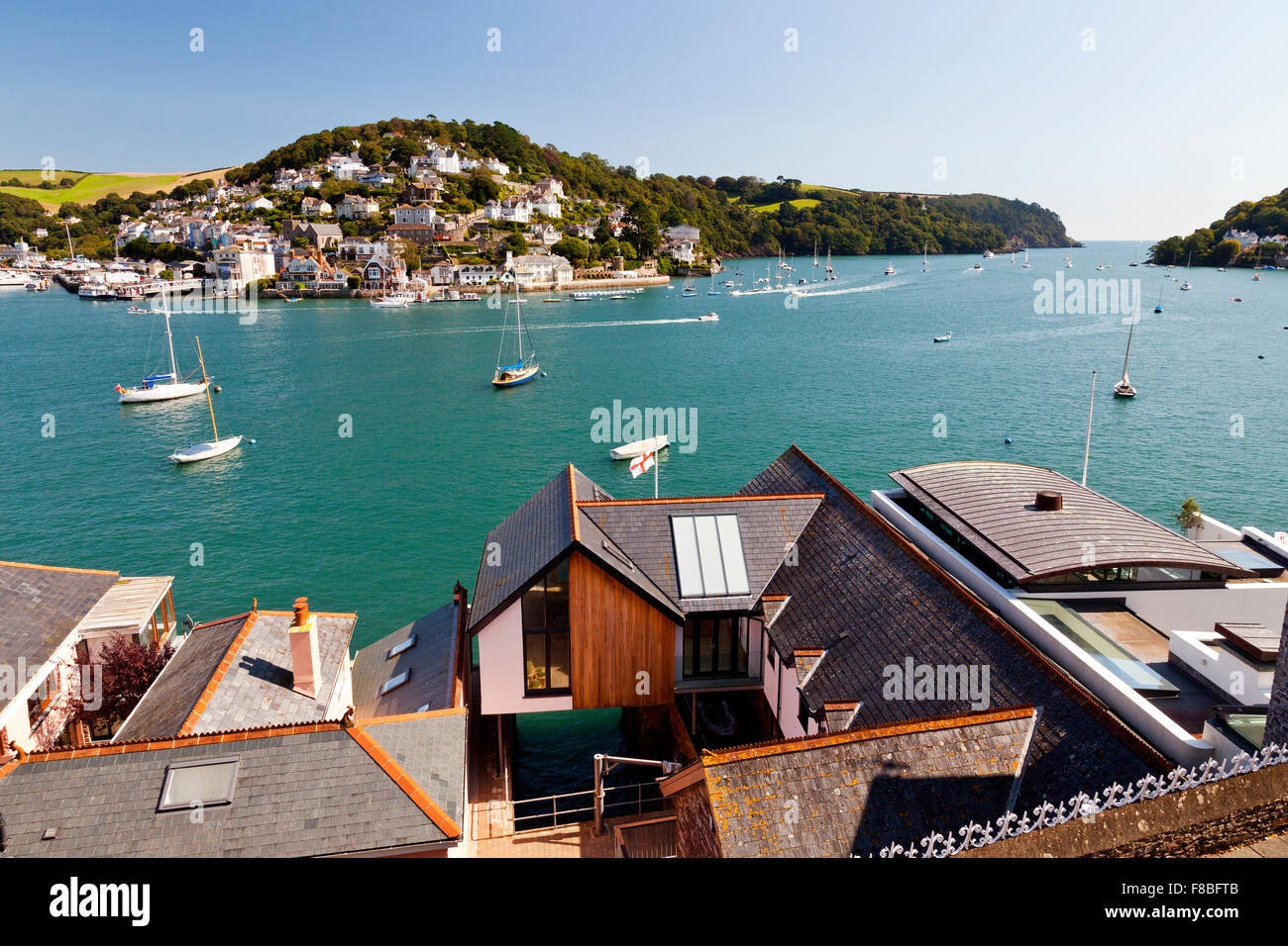 Looking out across the modern expensive waterfront houses on the River Dart towards Kingswear from Dartmouth, Devon, England, UK Stock Photo