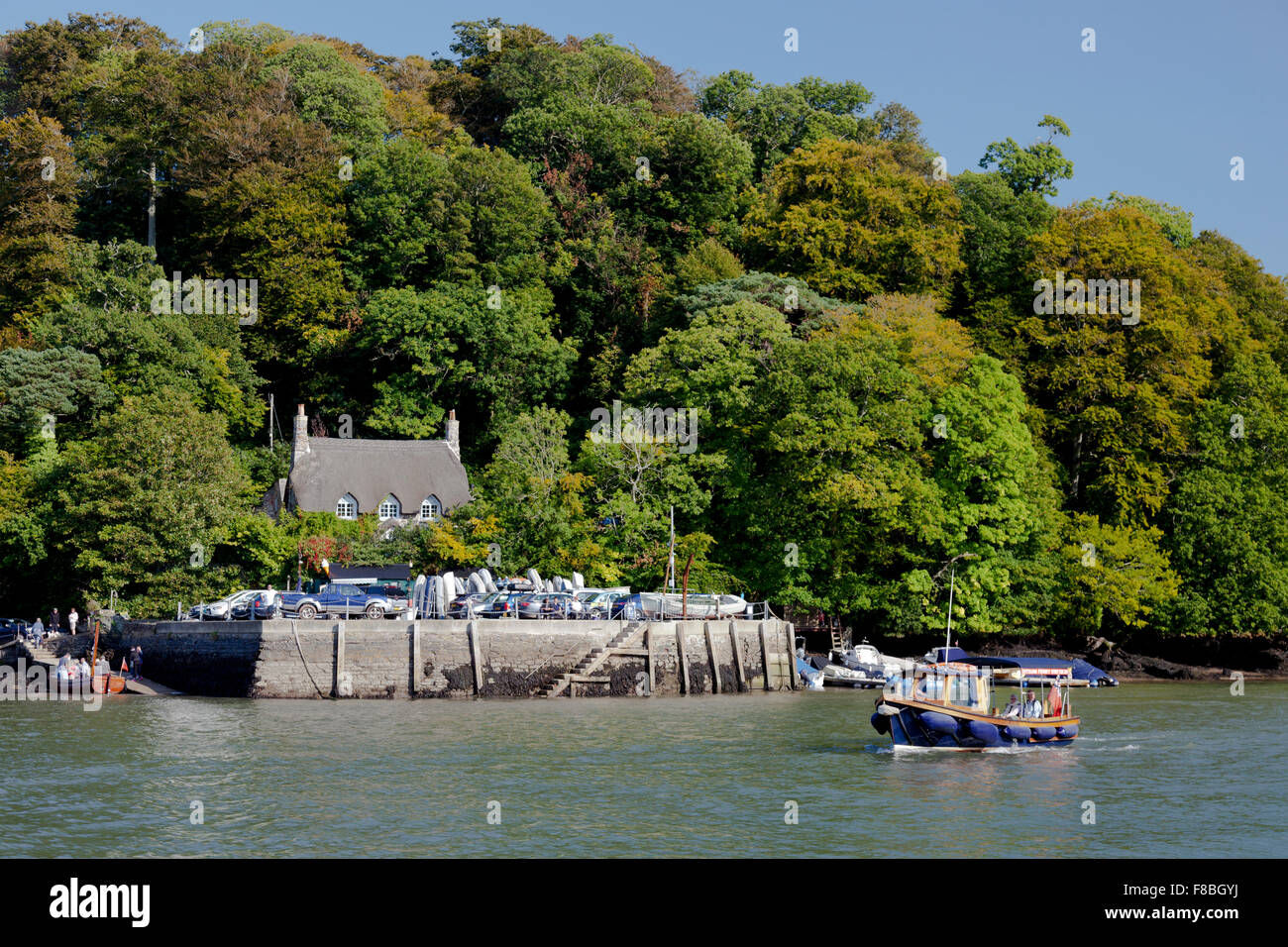 A thatched cottage surrounded by oak woodland at Greenway Quay, on the Greenway Estate, River Dart, Devon, England, UK Stock Photo