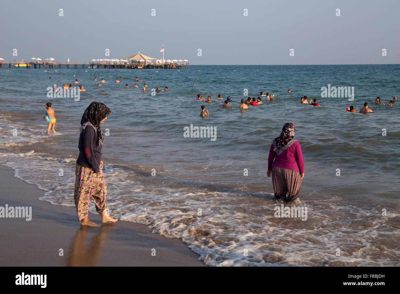 Turkish women bathing in the sea, with clothes, Side-Sorgun, Side Belediyesi, Turkish Riviera, Antalya, Turkey Stock Photo