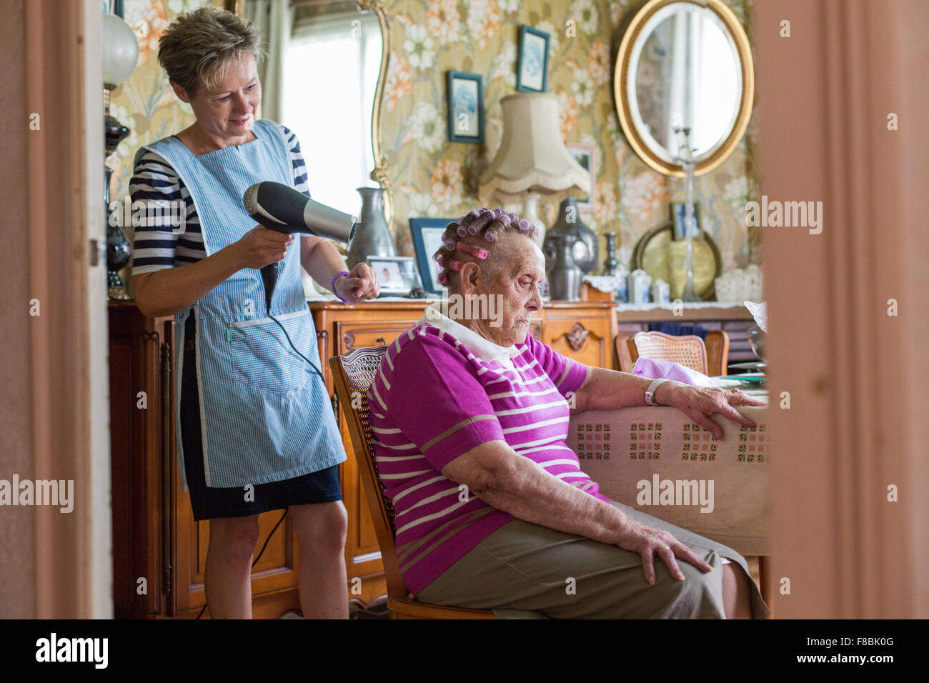 Home care aid assisting elderly woman, Dordogne, France. Stock Photo