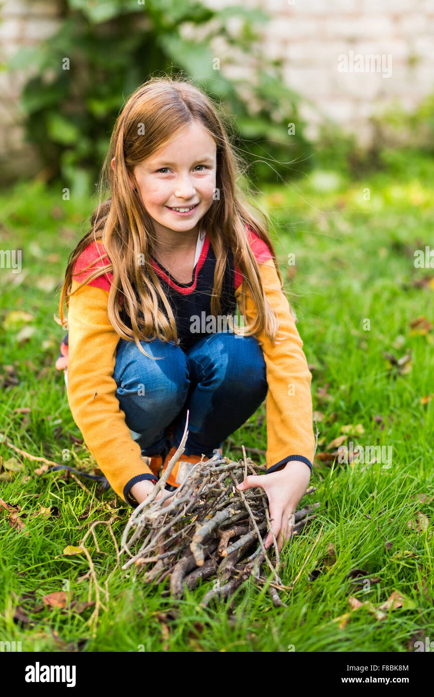 9-year-old girl collecting firewood. Stock Photo