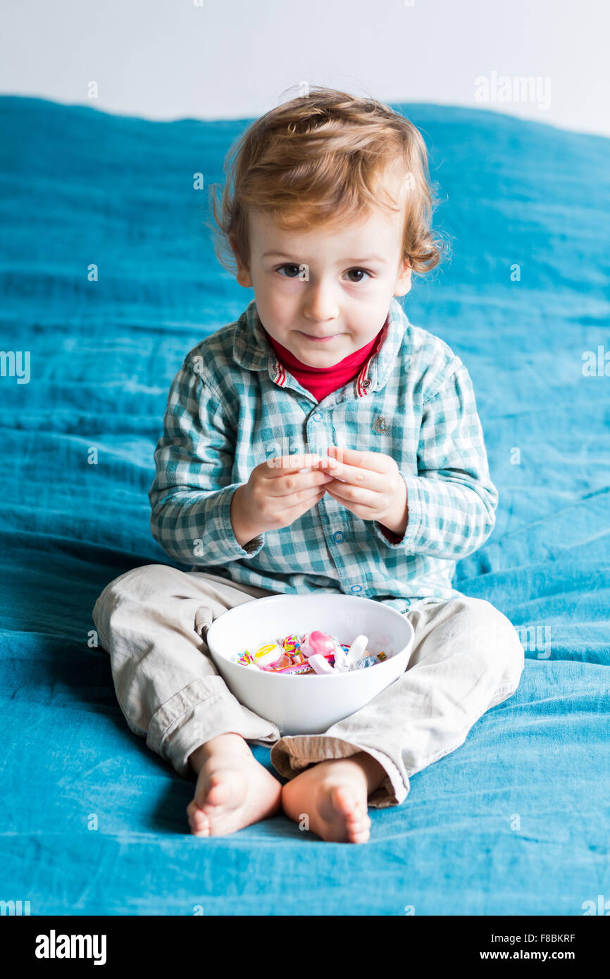 2 year-old boy eating sugary sweets. Stock Photo