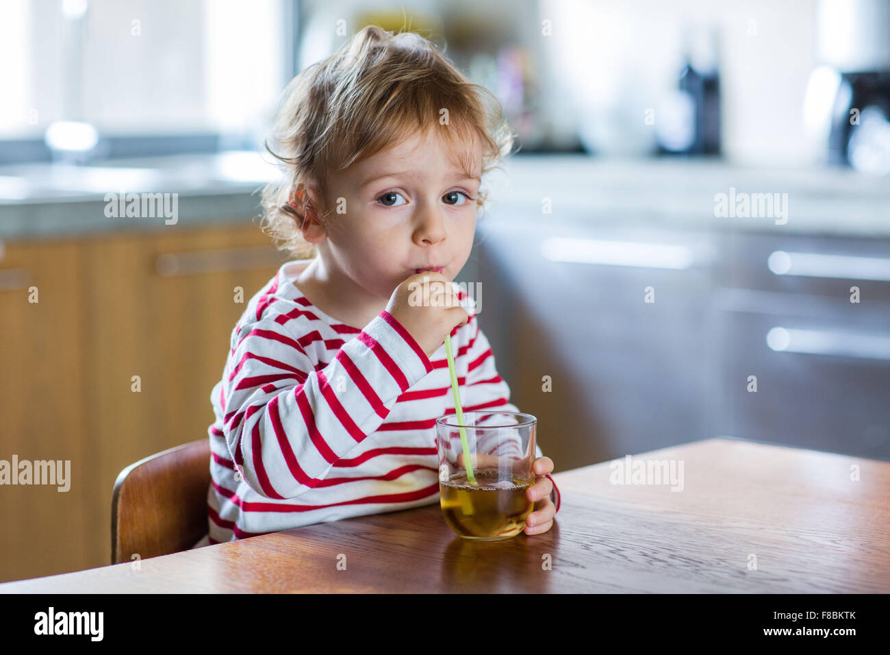 2 year-old boy drinking fruit juice. Stock Photo