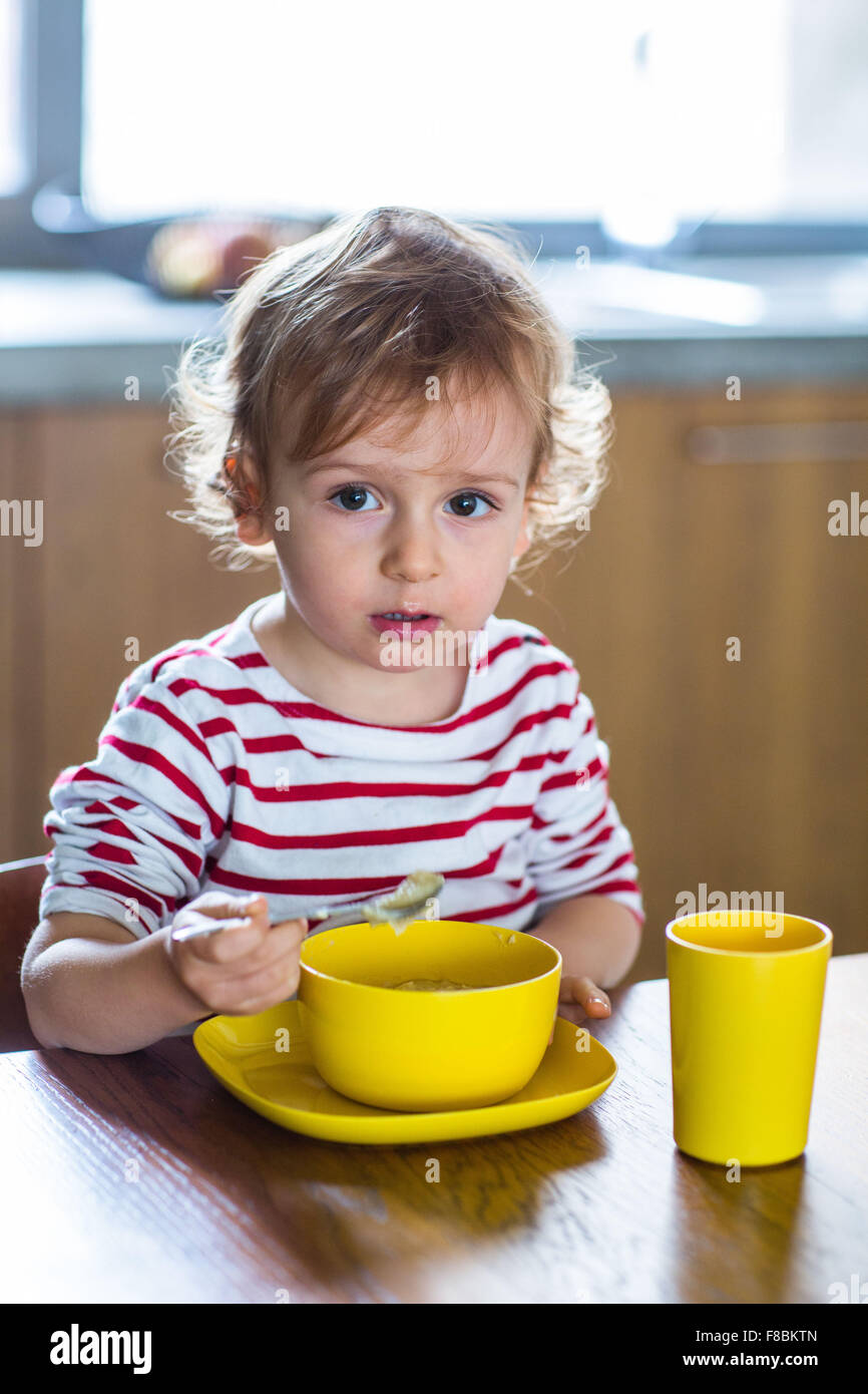 24 month old baby girl eating alone. Independence training. Stock Photo