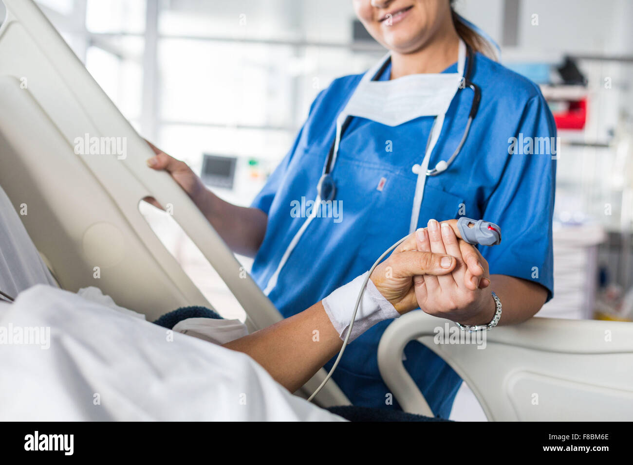 Nurse with a patient after heart surgery, Intensive care unit. Stock Photo