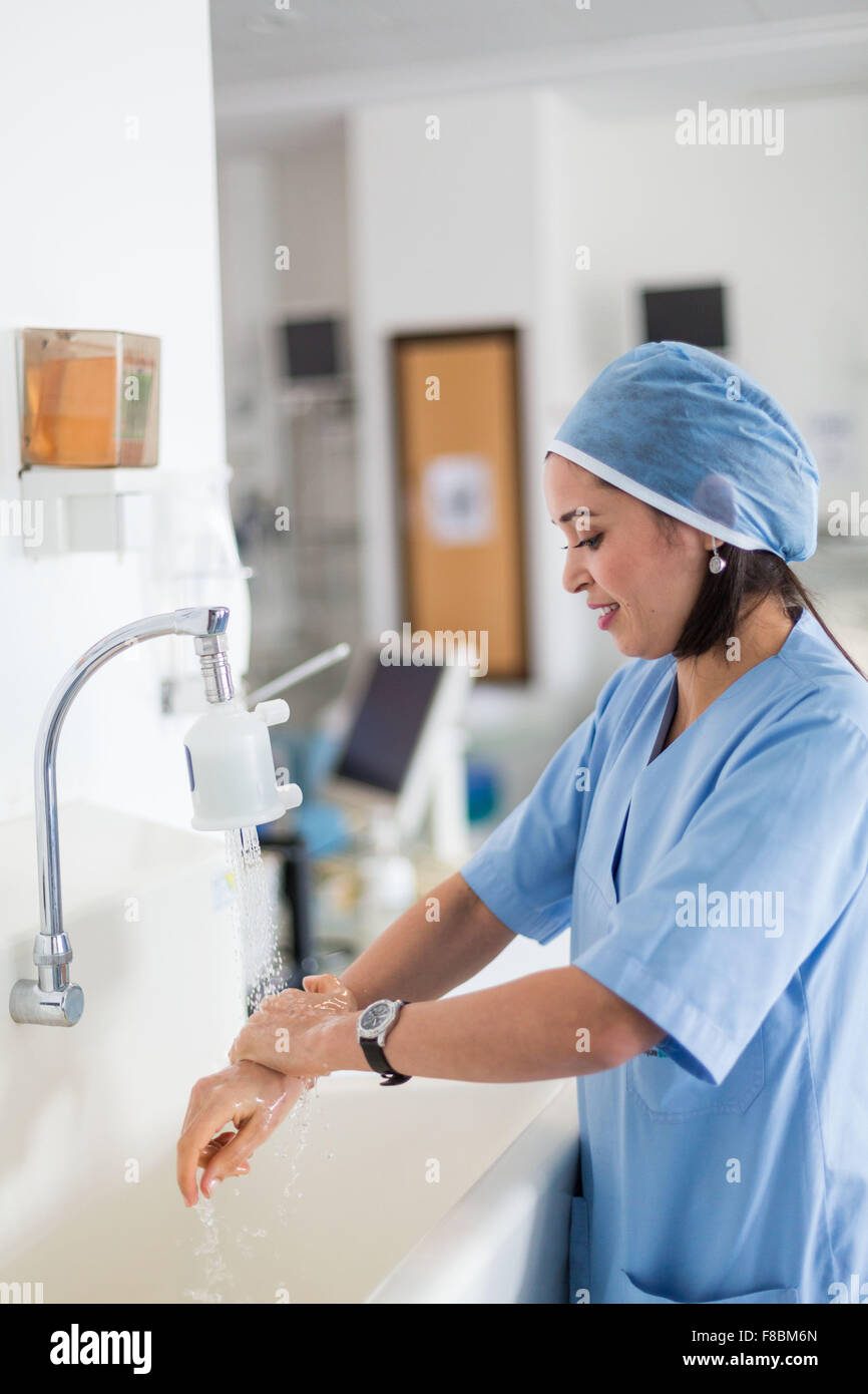 Nurse washing her hands at a sink. Stock Photo