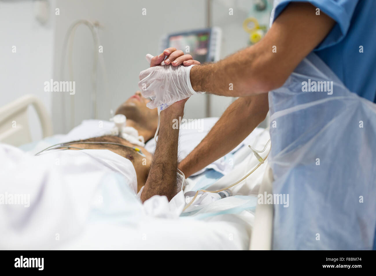 Physiotherapist with a patient in coma, Intensive care department. Stock Photo